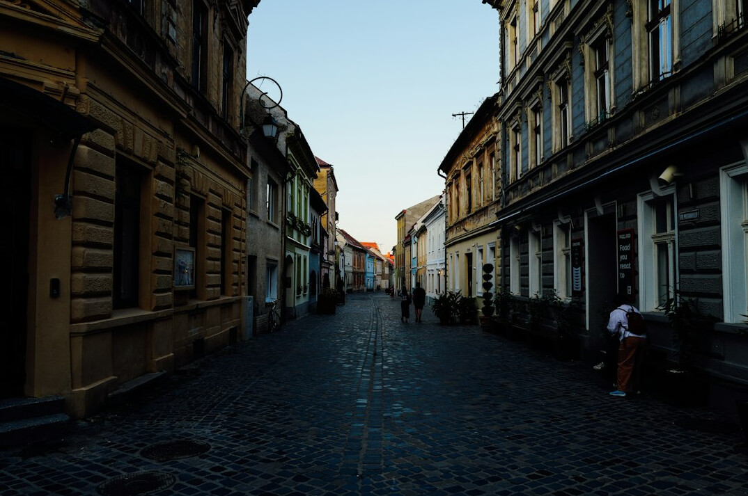 Quiet old city street at dusk with warm lights